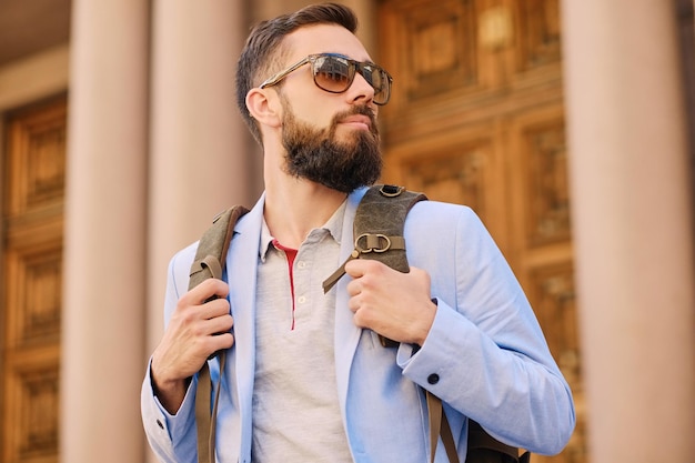 Uomo barbuto viaggiatore urbano con uno zaino.