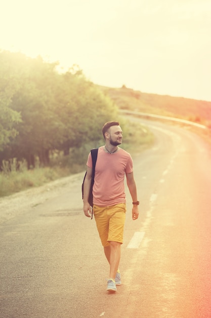 Uomo bello che cammina su una strada di campagna. Filtro instagram vintage retrò