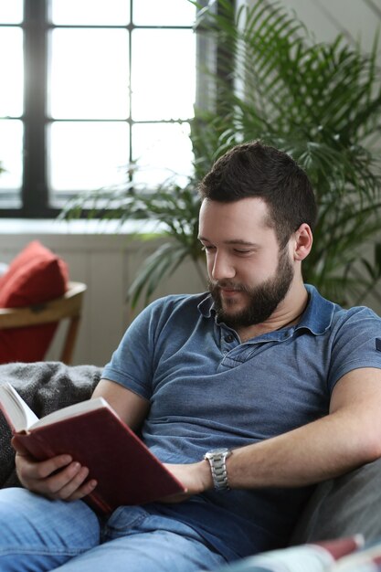 Uomo bello che legge un libro in pullman