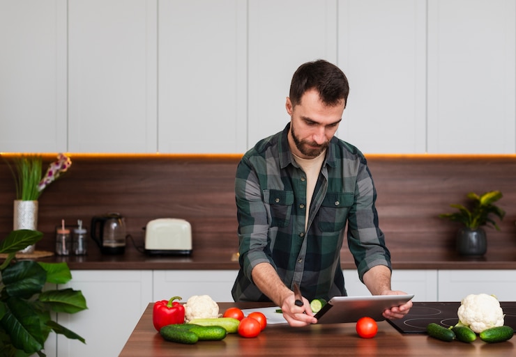 Foto gratuito uomo bello che osserva sul ridurre in pani in cucina