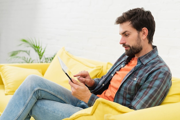 Uomo bello che osserva sul telefono