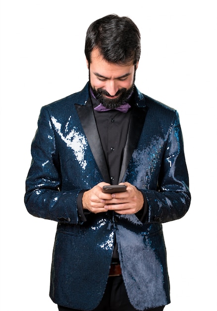 Uomo bello con giacca di paillettes parlando al cellulare