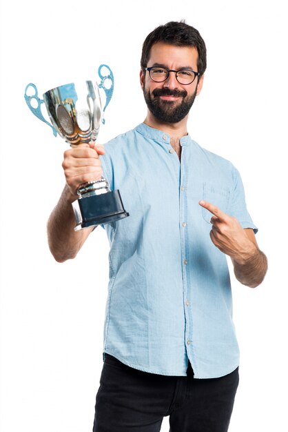 Uomo bello con gli occhiali blu che tengono un trofeo