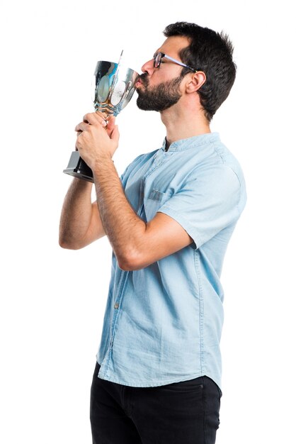 Uomo bello con gli occhiali blu che tengono un trofeo