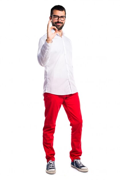 Uomo bello con gli occhiali che fanno segno OK