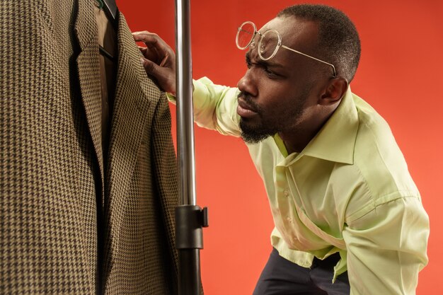 Uomo bello con la barba che sceglie camicia in un negozio