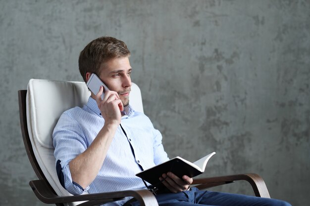 Uomo bello con smartphone e notebook