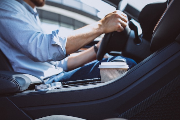 Uomo bello di affari che viaggia in automobile