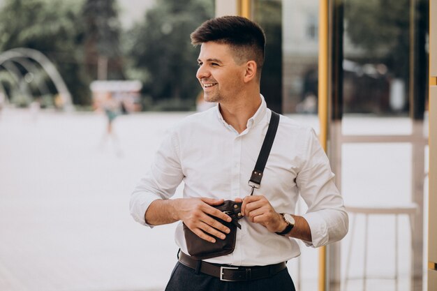 Uomo bello di affari in camicia bianca fuori