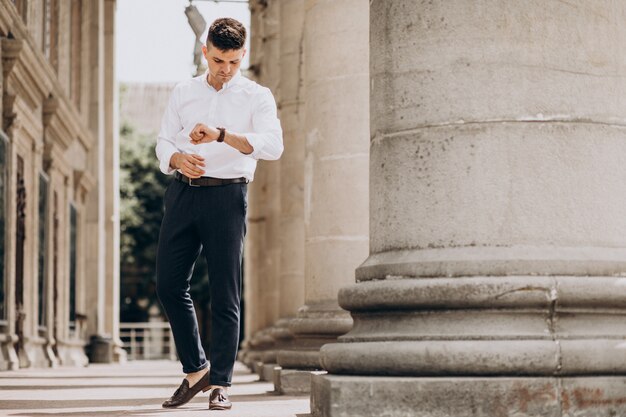 Uomo bello di affari in camicia bianca fuori