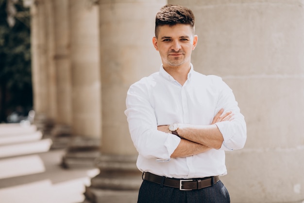 Uomo bello di affari in camicia bianca fuori