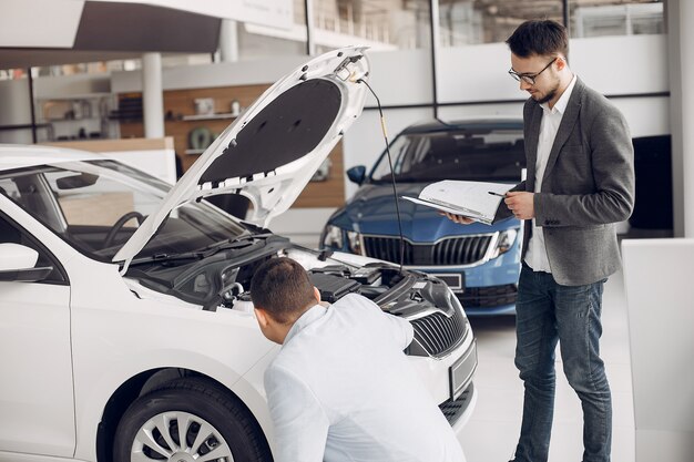 Uomo bello ed elegante in un salone di auto