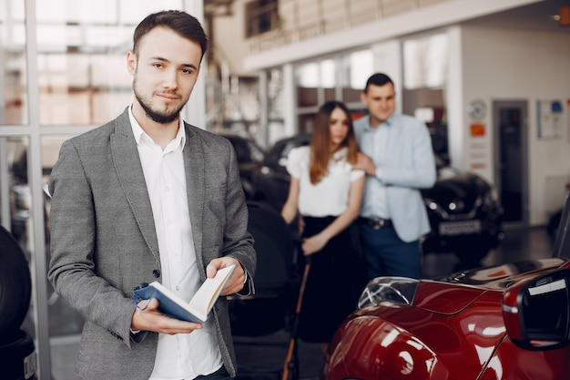 Uomo bello ed elegante in un salone di auto