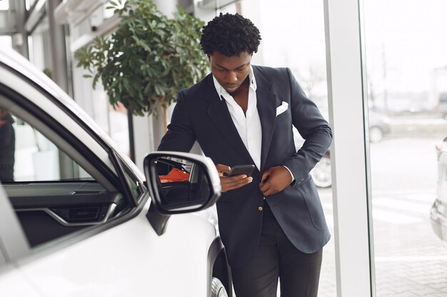 Uomo bello ed elegante in un salone di auto