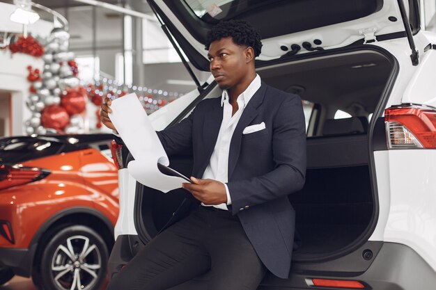 Uomo bello ed elegante in un salone di auto