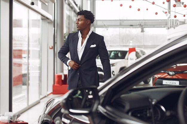 Uomo bello ed elegante in un salone di auto