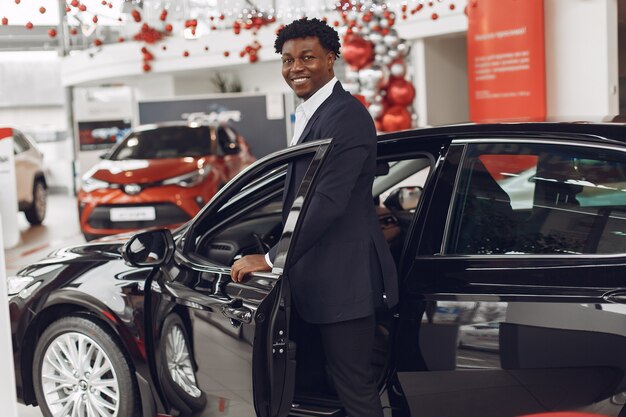 Uomo bello ed elegante in un salone di auto