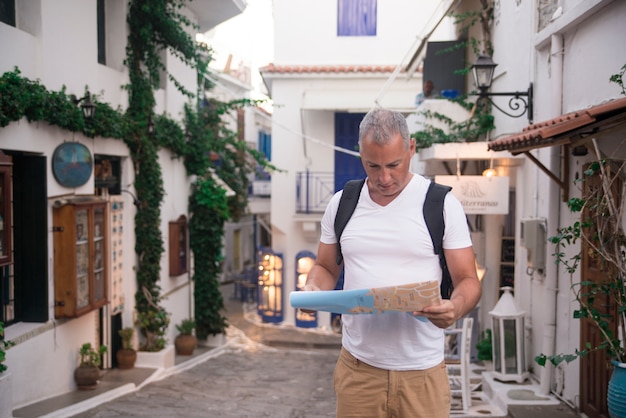 Uomo bello guardando la mappa della città in un viaggio