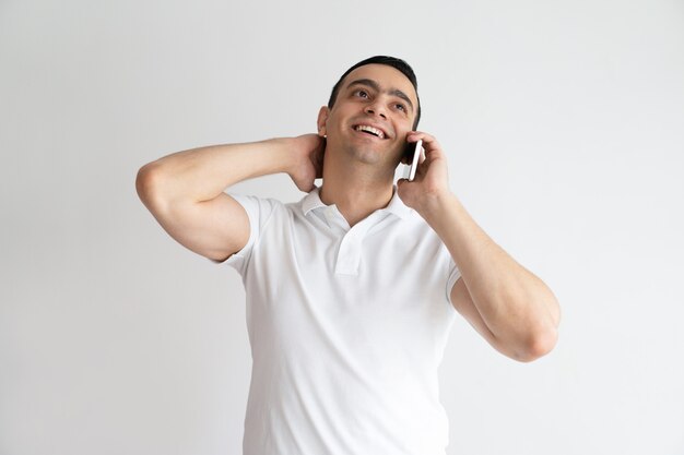 Uomo bello rilassato che parla sul telefono cellulare. Sorridente giovane ragazzo chiamata su smartphone.