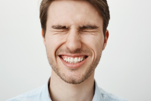 Uomo bello sorridente felice con gli occhi chiusi