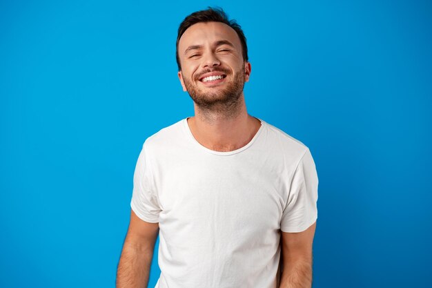 Uomo bello sorridente felice su sfondo blu