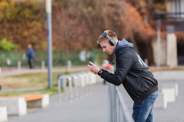 Uomo biondo di vista laterale che ascolta la musica all'aperto