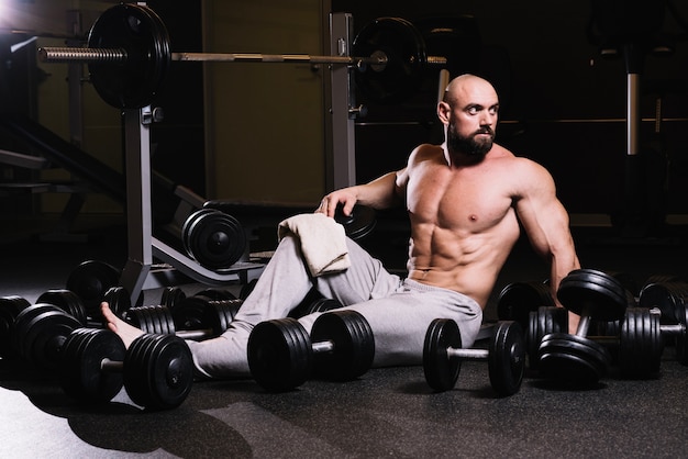 Uomo calvo in mezzo a dumbbells che guardano lontano