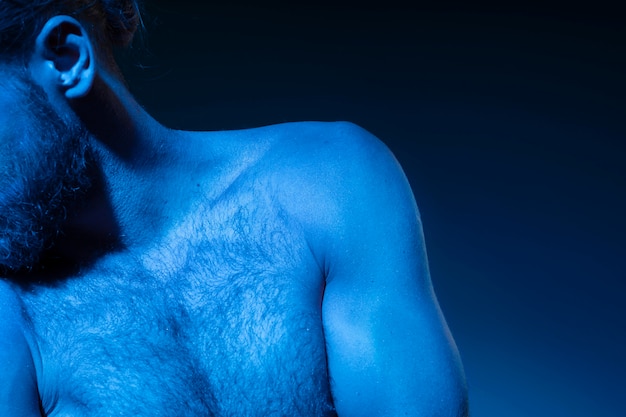 Uomo caucasico a torso nudo nei toni del blu