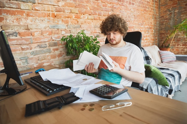 Uomo caucasico sconvolto e disperato che fa rapporti finanziari ed economici