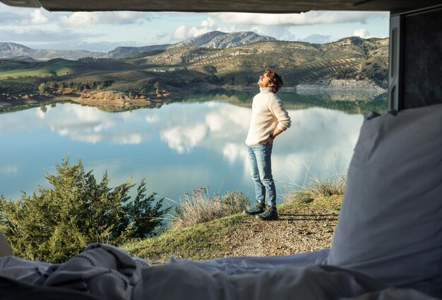 Uomo che ammira la natura durante un viaggio su strada