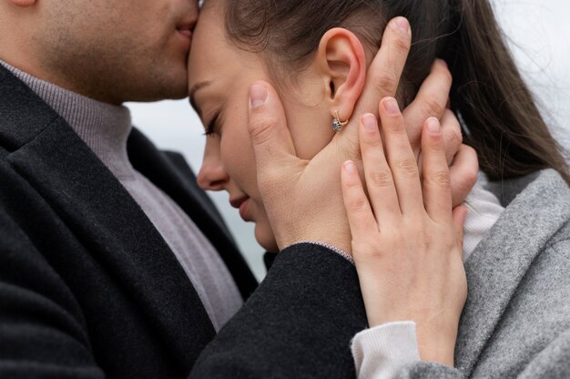 Uomo che bacia la fronte della donna da vicino