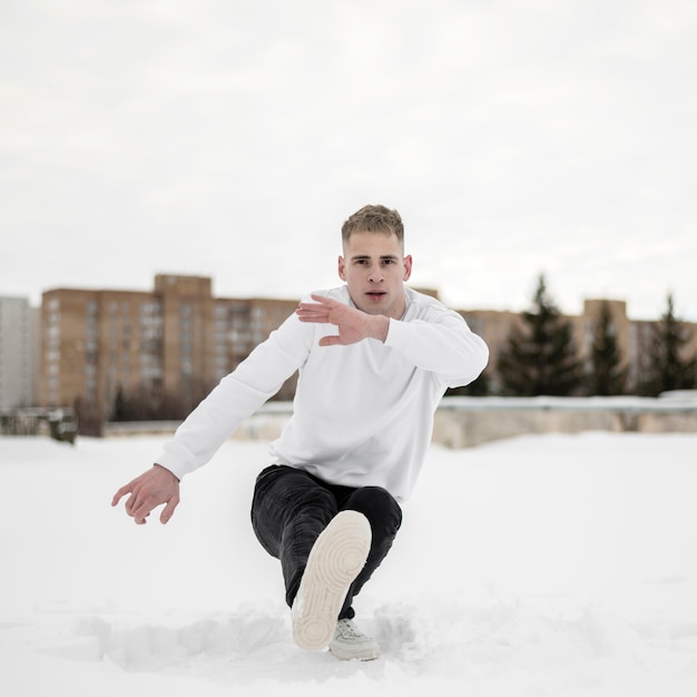 Uomo che balla all'hip hop nella neve