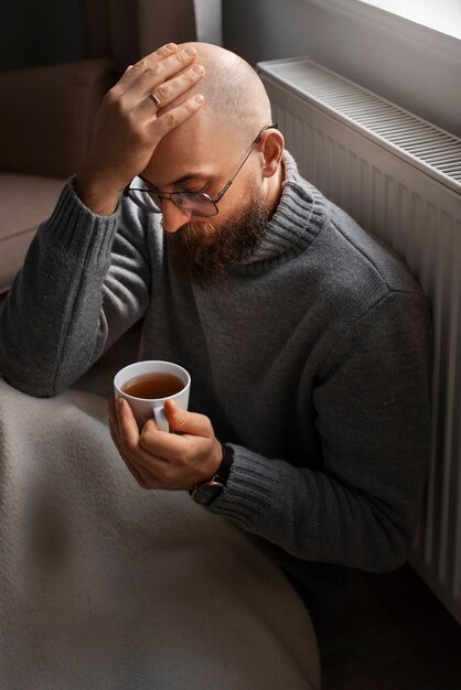 Uomo che beve bevande calde durante la crisi energetica