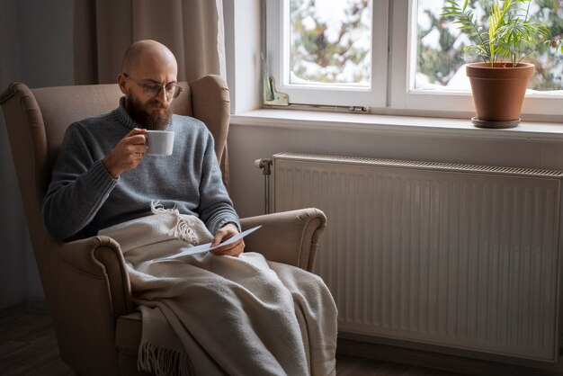 Uomo che beve bevande calde durante la crisi energetica