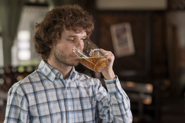 Uomo che beve birra al bar