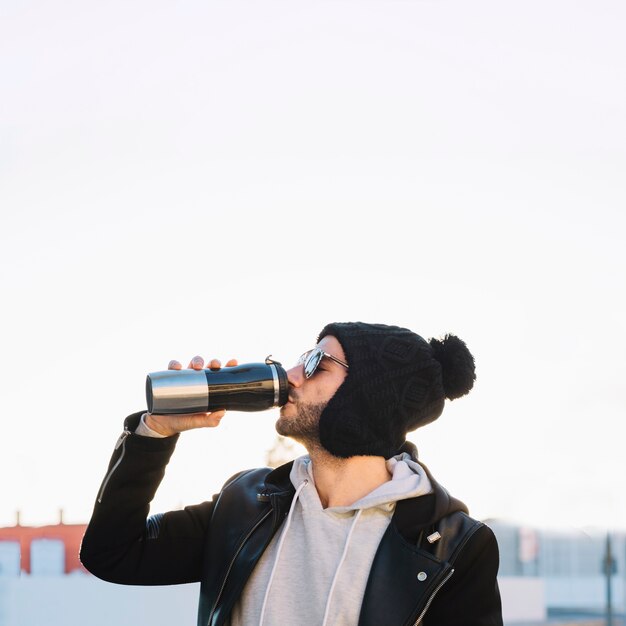 Uomo che beve dal thermos