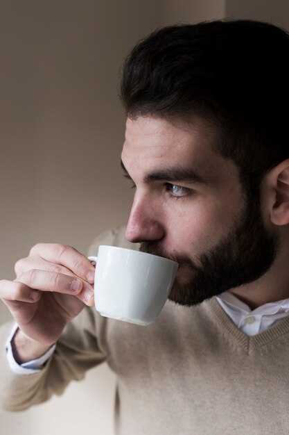 Uomo che beve e guarda lontano