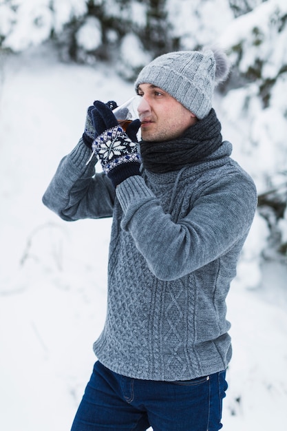 Uomo che beve il tè in inverno