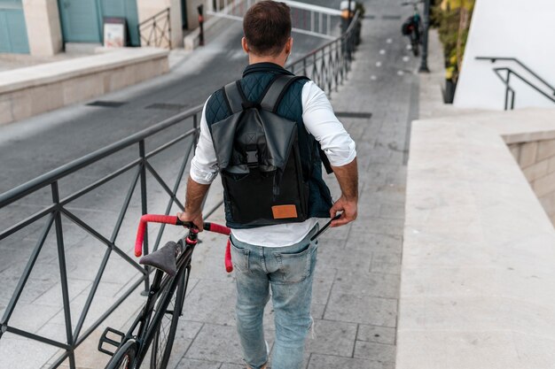 Uomo che cammina accanto alla sua bici