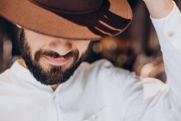 Uomo che cerca cappello al negozio per uomo