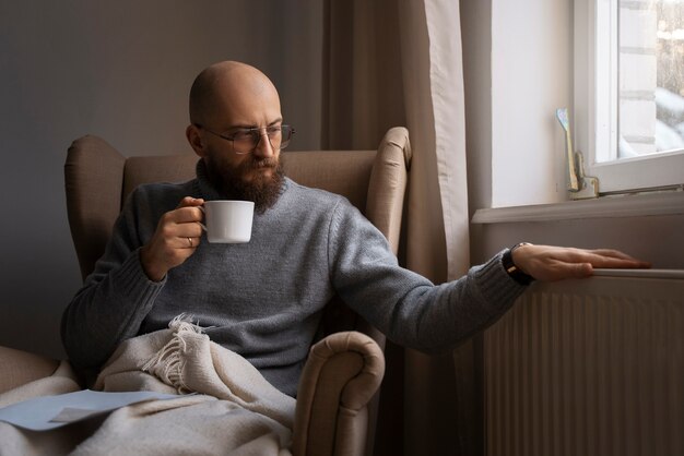 Uomo che cerca di stare al caldo durante una crisi energetica