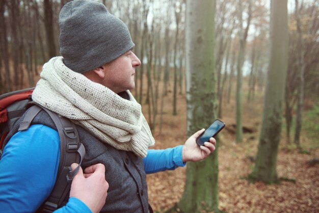 Uomo che cerca il segnale nella foresta