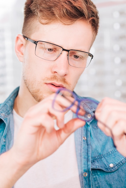 Uomo che cerca nuovi occhiali all&#39;optometrista