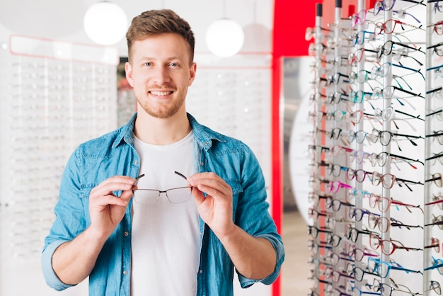 Uomo che cerca nuovi occhiali all&#39;optometrista