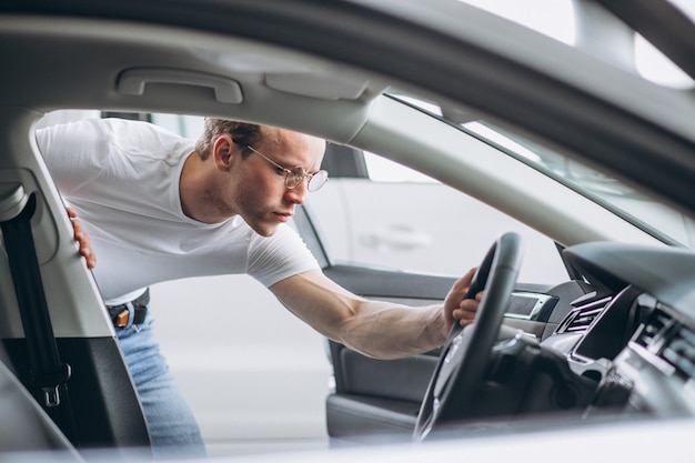 Uomo che cerca un&#39;auto in uno showroom di auto