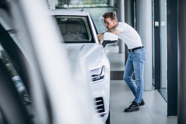 Uomo che cerca un&#39;auto in uno showroom di auto