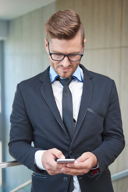 Uomo che controlla alcuni documenti importanti sul telefono