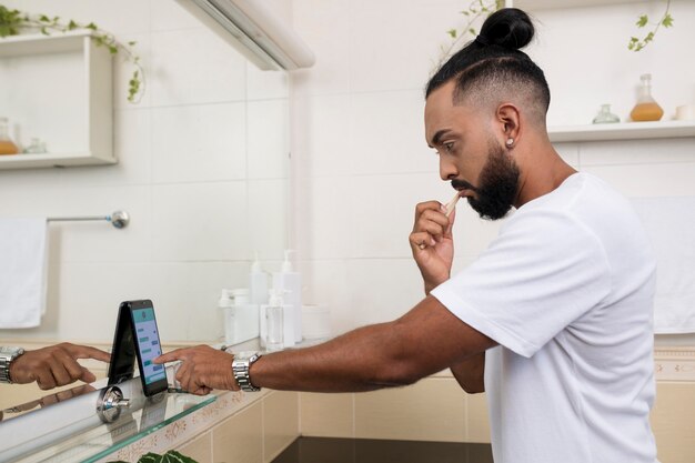 Uomo che controlla il telefono anche in bagno