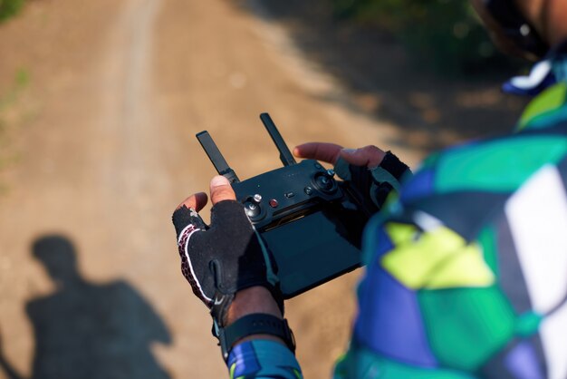 Uomo che controlla un drone nella foresta