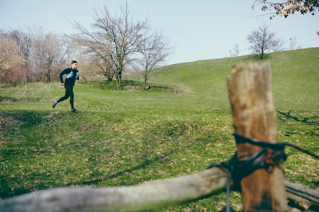 Uomo che corre in un parco o in una foresta contro gli alberi